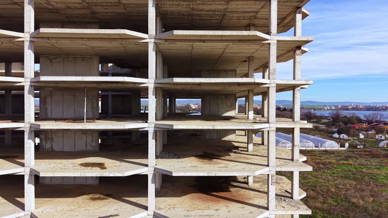 Urban exploration of an unfinished concrete structure revealing architectural beauty in an abandoned site by the water's edge