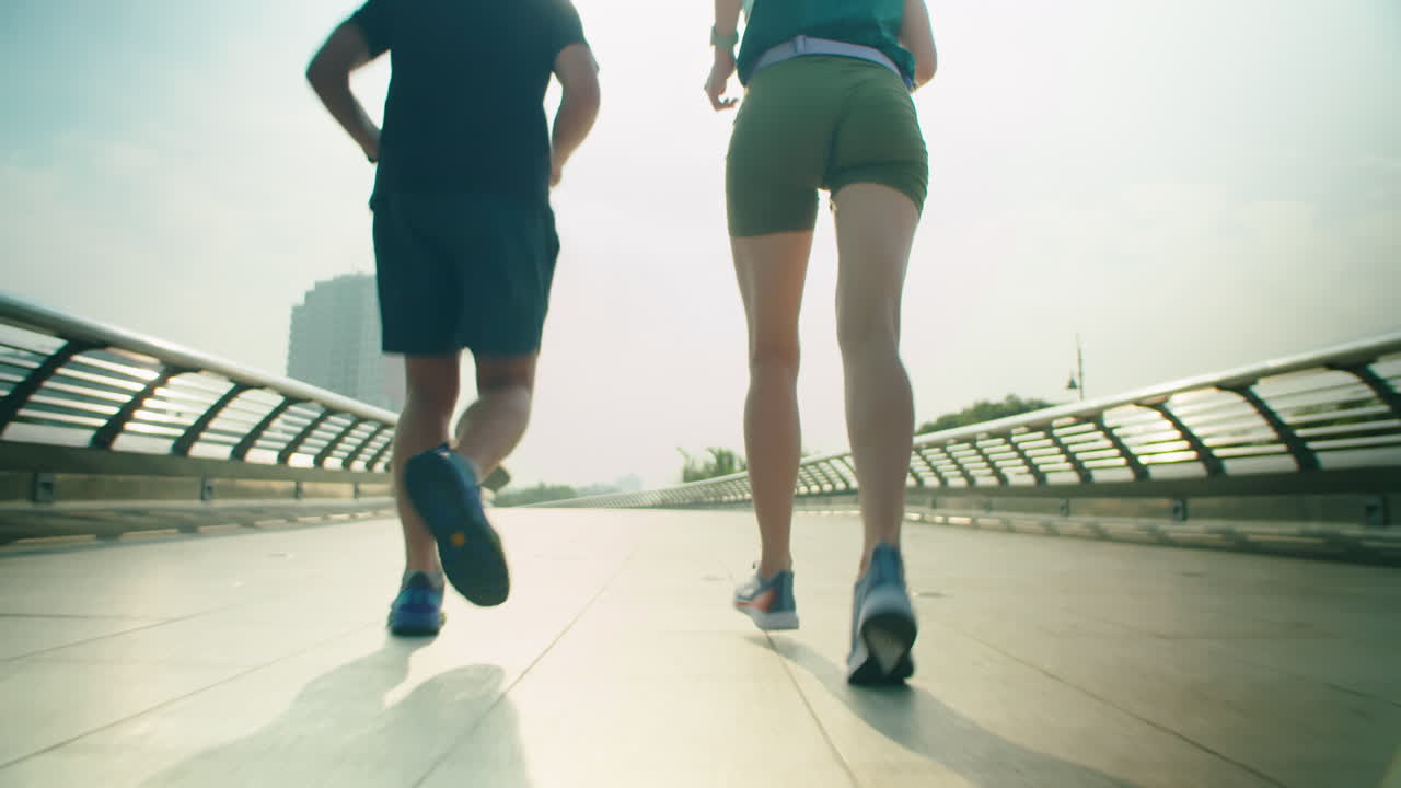 Athletic Couple Running on Footbridge in City