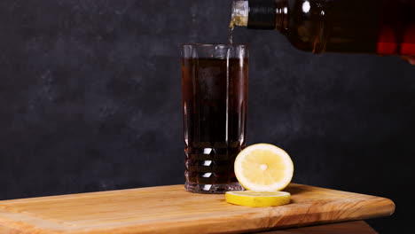 piscola cocktail, typical chilean drink wooden table dark background chile pisco, ice and coke