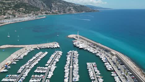 Boat-marina-at-seaside-town-on-Menton-in-Southern-France,-Aerial-pan-left-shot