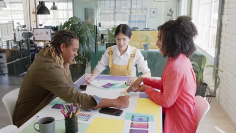 ocupados diversos diseñadores diversos en la mesa discutiendo el trabajo en una reunión de oficina casual, en cámara lenta