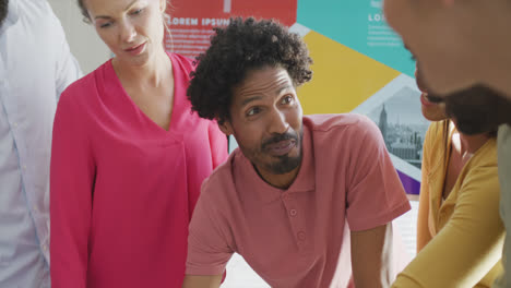 Diverse-male-and-female-business-colleagues-discussing-at-meeting-in-office