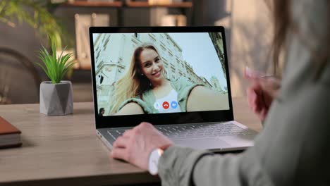 Frau-Videochattet-Mit-Fröhlichem-Mädchen-über-Laptop-Webcam,-Während-Sie-Im-Zimmer-Am-Tisch-Sitzt