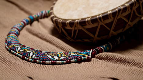 beaded necklace and drum on burlap