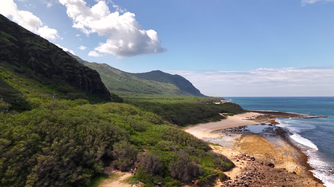 Remote and wild coastline of Makua Beach nestled against mountains in Oahu