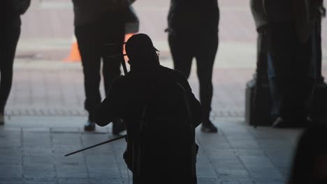 close up silhouetted man plays violin for passing people in new york central park