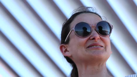 casual happy smiling woman wearing round sunglasses candid laugh