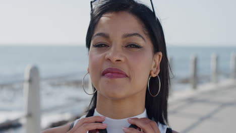 portrait stylish hispanic woman smiling enjoying successful vacation lifestyle relaxing wind blowing hair beautiful young female looking happy on warm seaside background