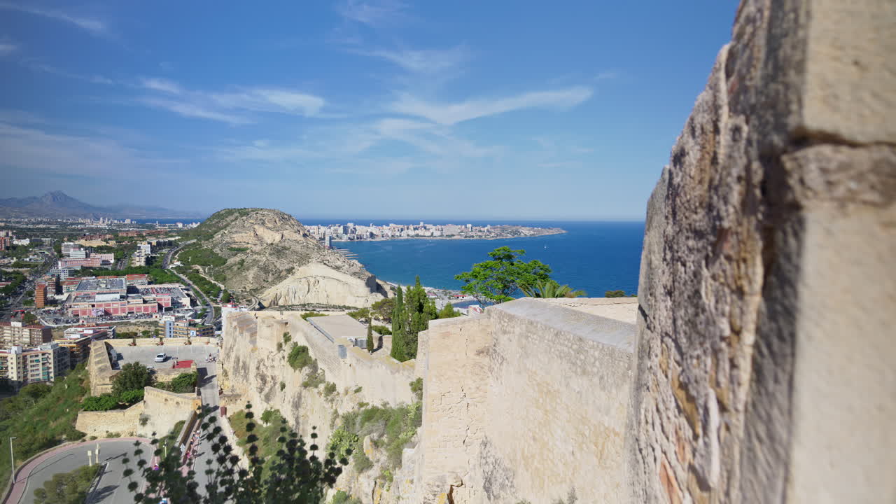 A stone embrasure to the blue Mediterranean and Alicante skyline beyond