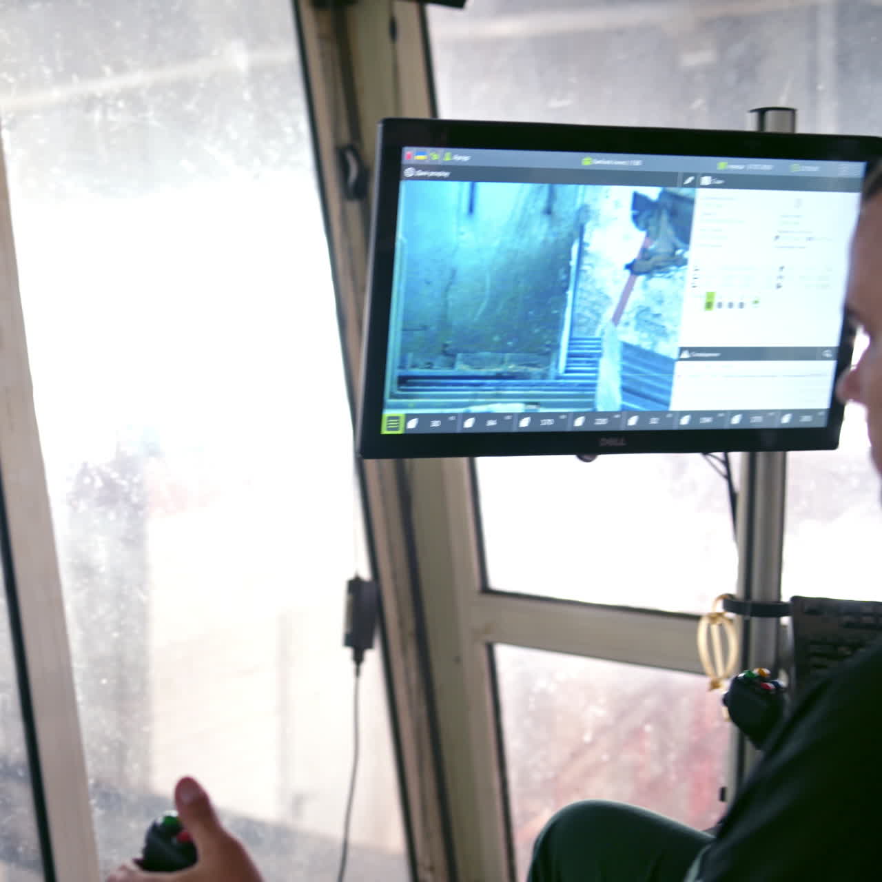 Robotic power-saw bench indoors. Worker looking on the monitor where automated machine cutting wood. Modernized equipment inside the woodworking plant.