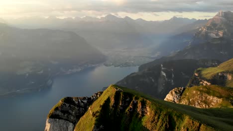 Paso-Elevado-Giratorio-Alrededor-De-La-Cumbre-De-Niederbauen-Chulm-En-Una-Mañana-Dorada-De-Verano-En-Los-Alpes-Suizos-Con-Vistas-A-Los-Fiordos-Del-Lago-Lucerna,-Mythen,-Rigi,-Burgenstock,-Pilatus