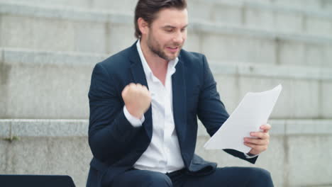 business man looking business papers on street. entrepreneur celebrating success