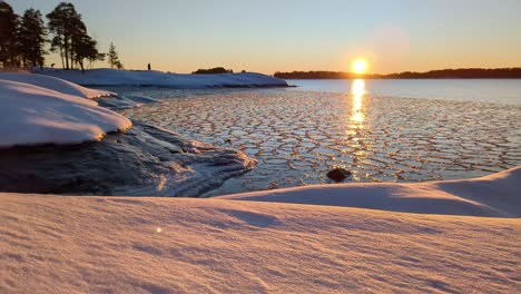 magical sunset moment winter sea landscape with snowy nature, golden hour by frozen sea
