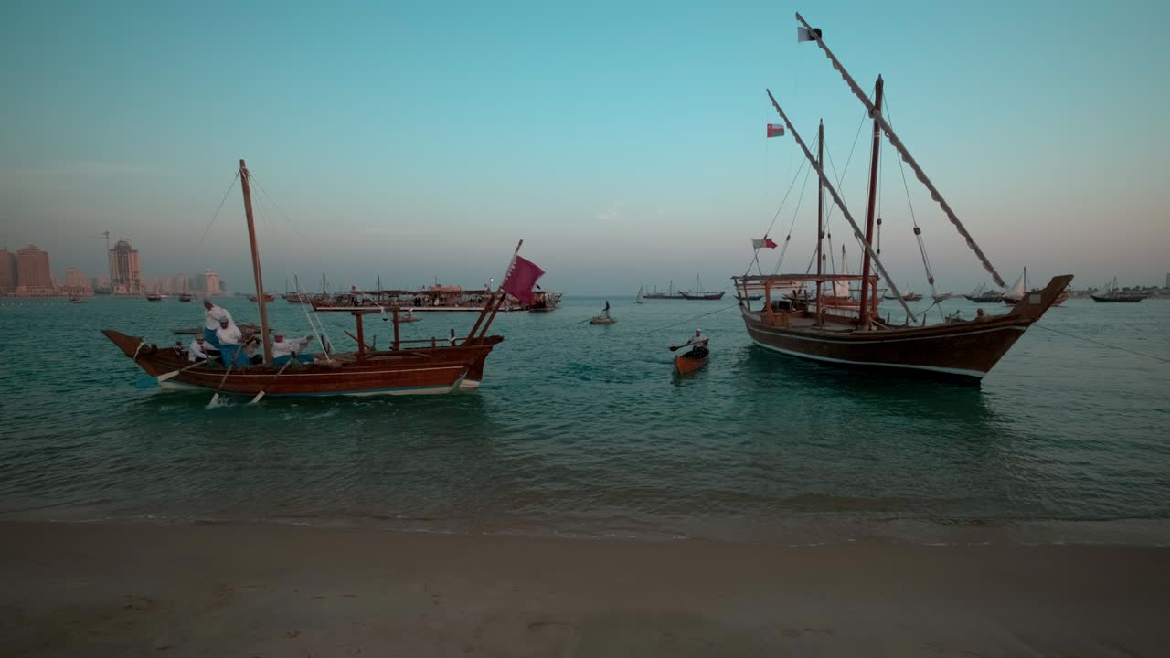 Dhow con bandiera del Qatar nel Golfo Arabico nel villaggio culturale di Katara, Doha, Qatar.