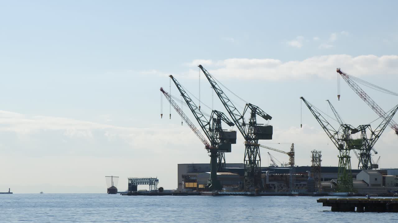 Shipping seaport cranes on waterfront pier with blue sky copy space