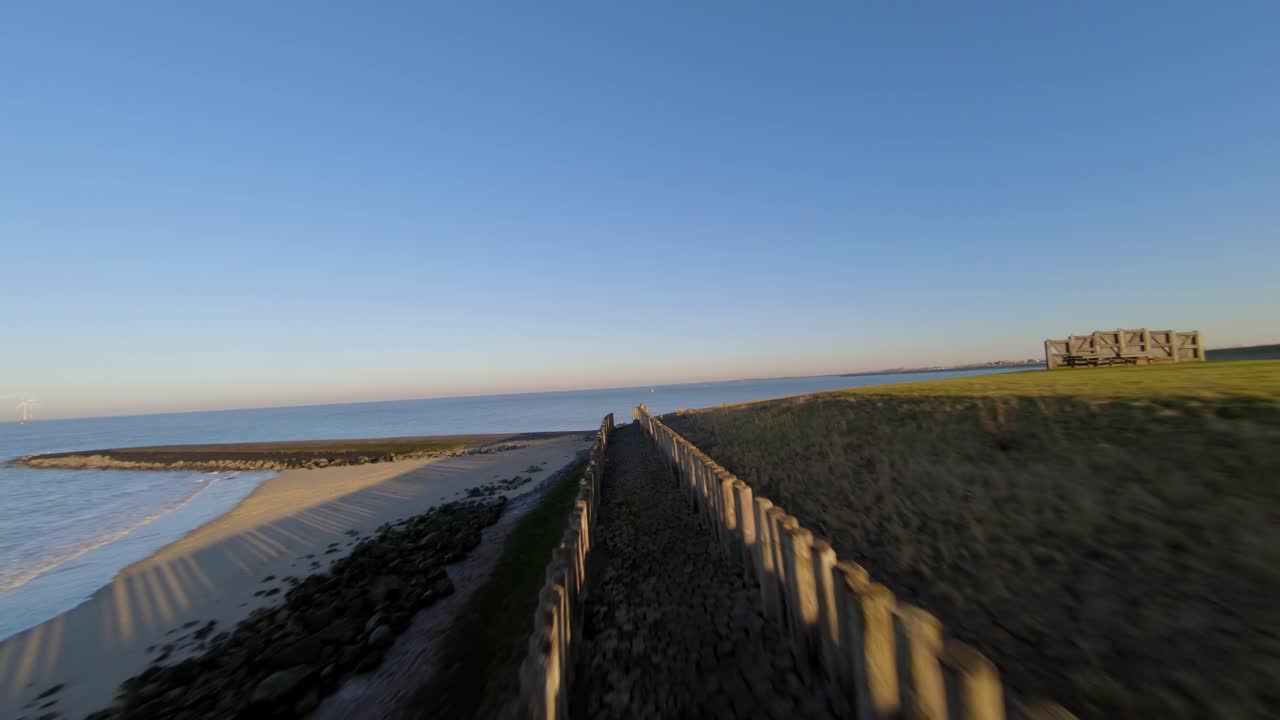 Fast moving shot above wooden poles on a dyke in the Netherlands