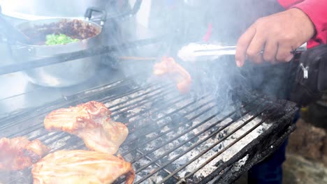 grilling chicken over smoky barbecue outdoors