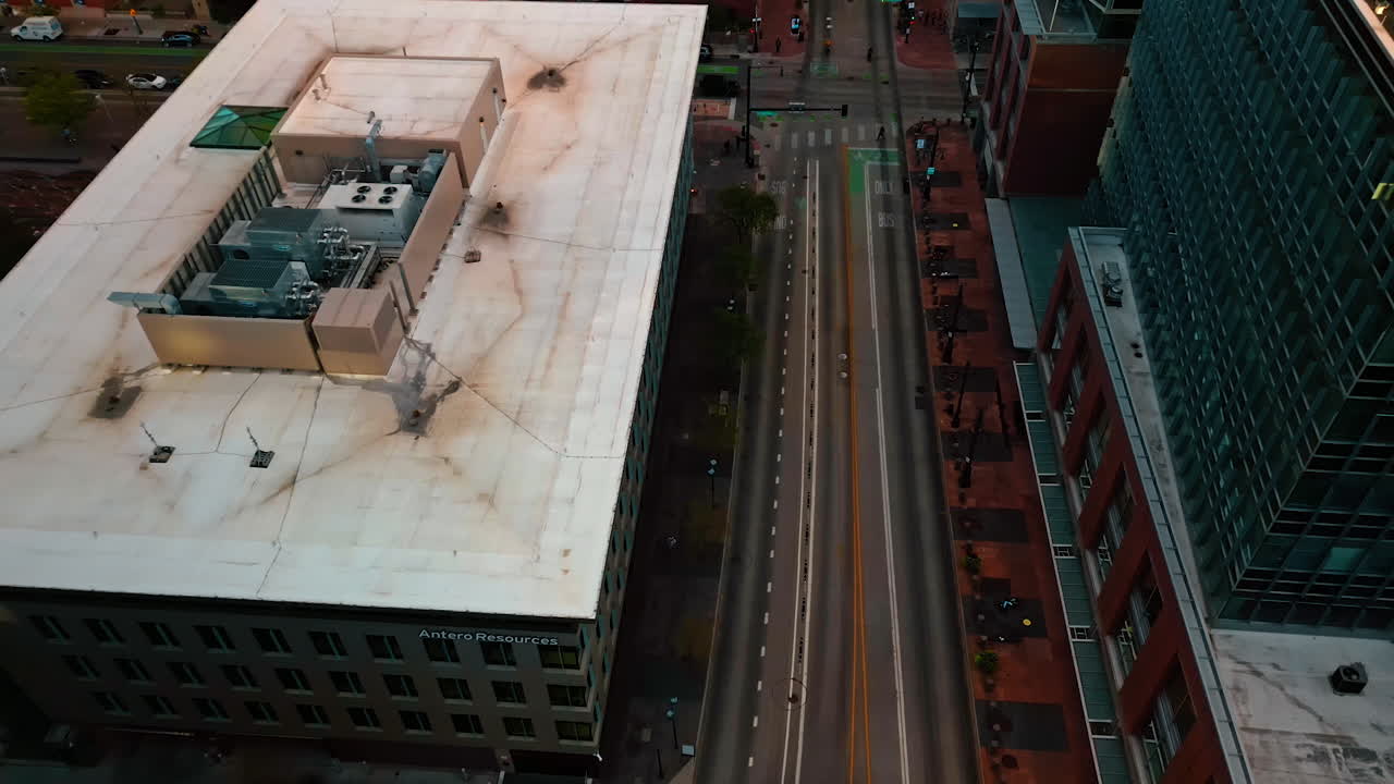 Denver, USA, 24 August 2025: Approaching the empty street with few bikes moving by. Drone footage over the cityscape of Denver, Colorado, USA