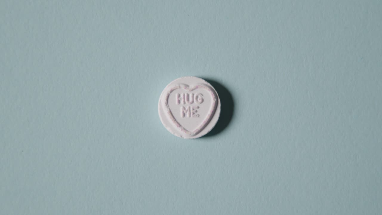 파란색 배경에 나를 안아줘 메시지와 함께 심장 사탕을 손에 들고