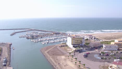 Una-Ciudad-Junto-Al-Mar-Con-Un-Puerto-Lleno-De-Barcos