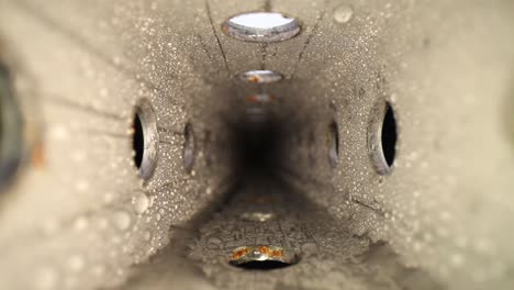 pushing into a wet zinc-plated steel perforated square tube with a wide angle macro probe lens - rolling the focus from the front to the back of the tube and visa versa