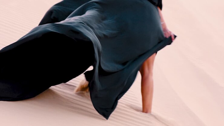 Vivi il romanticismo nell'affascinante deserto di Dubai mentre una coppia, vestita con abiti eleganti, condivide un momento bellissimo tra le dune mozzafiato
