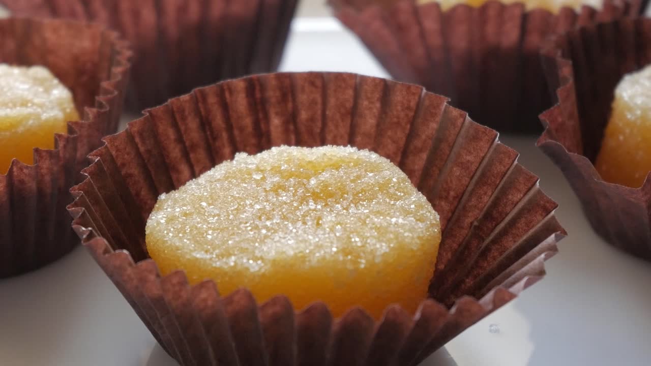 Sweet egg yolk treats in brown paper cups, traditional Spanish yemas dessert