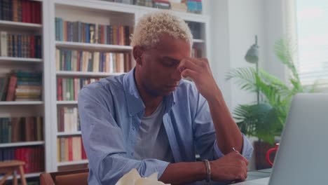 tired afro american businessman feels exhausted with laptop and crumpled papers