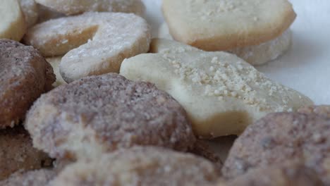 a close-up pan from upper left to bottom right, filling the frame with brown german butterplätzchen cookies, capturing their crumbly texture and authentic, homemade appeal