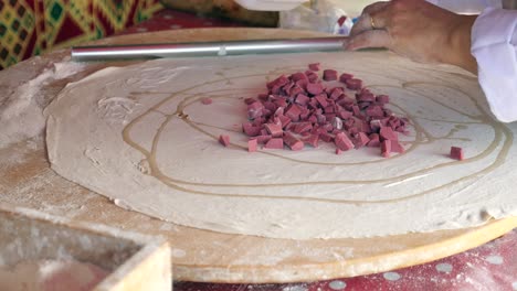 chef preparing delicious flatbread with meat filling