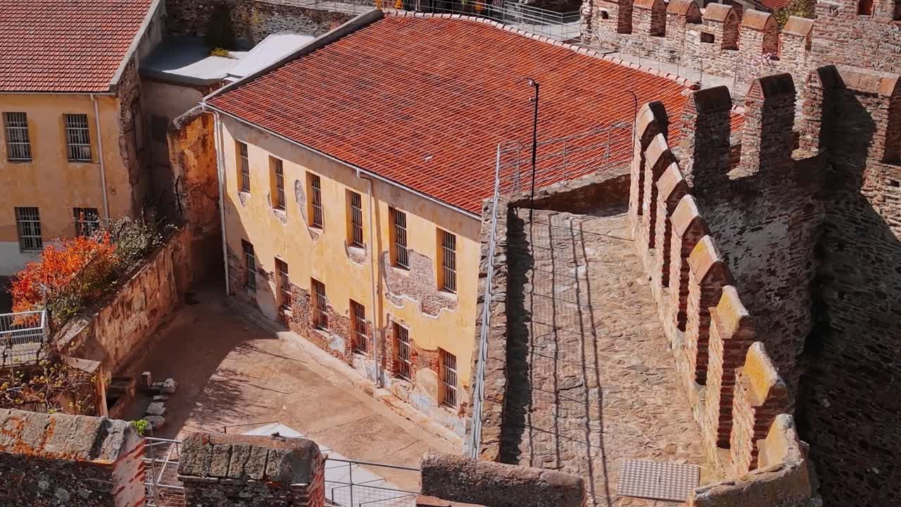 Edificio in Grecia vicino a vecchi muri di pietra in pieno sole