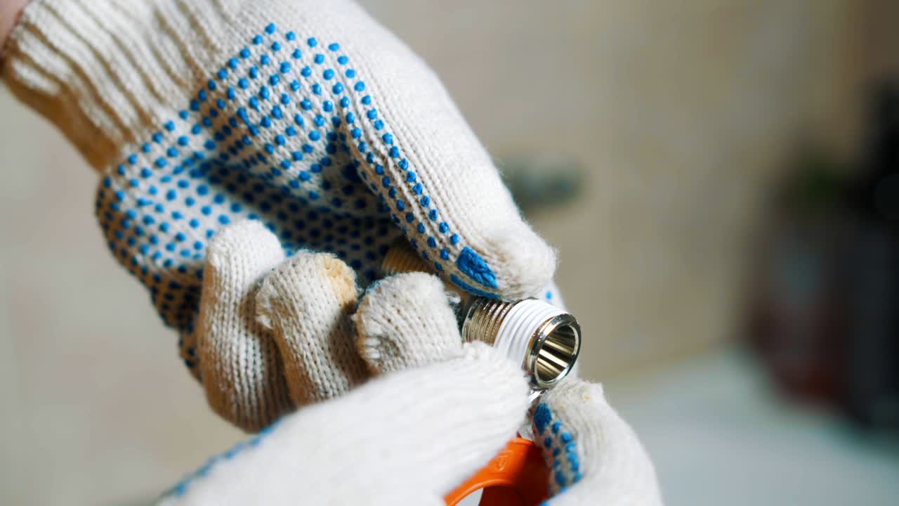 cerca de un hombre está sellando cinta de envoltura alrededor del tornillo del grifo de agua de hierro