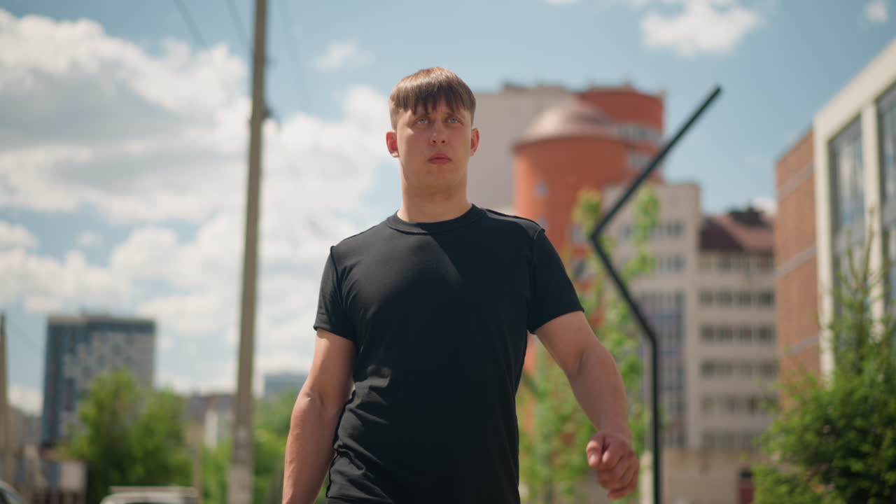 Joven profesional urbano; joven y resuelto fundador de startup camina hacia una reunión de negocios al aire libre; emprendedor joven y optimista se abre paso por las concurridas aceras de la ciudad de camino a una reunión importante.