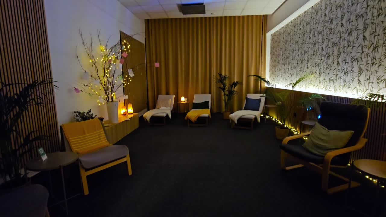Afslappende spa-afslapningsrum med hyggelige stole og stemningsfuld belysning