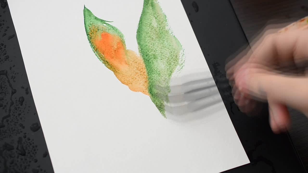 Artist draw a flower on a drawing paper. We draw water color paints