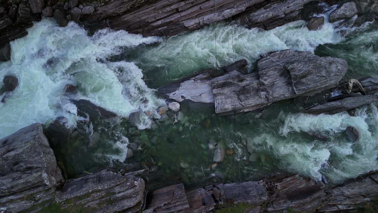 Cold water above mountain stream river, aerial drone top down view Switzerland