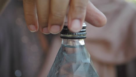 a person opening a bottle of water