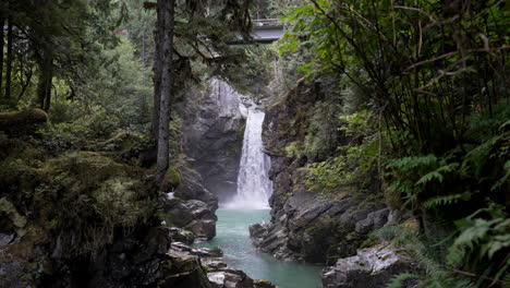 water from mamquam falls flowing into rocky and narrow stream in squamish, bc, canada