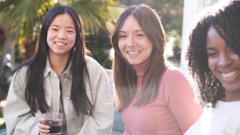 smiling female friends in backyard on weekend party