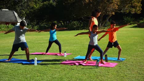 yoga instructor instructing children in performing exercise