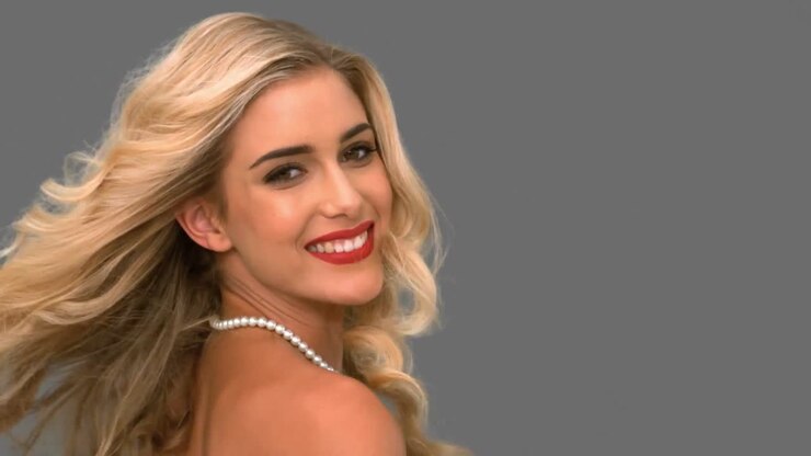 привлекательная женщина бросает волосы на сером экране