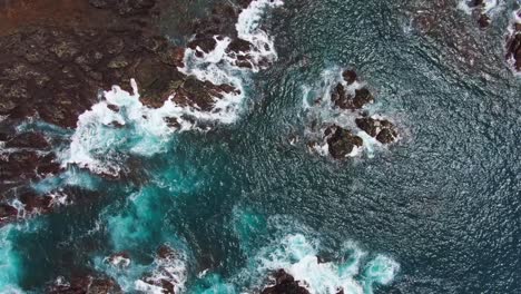 beautiful turquoise blue ocean water with white waves crashing into rocky coast