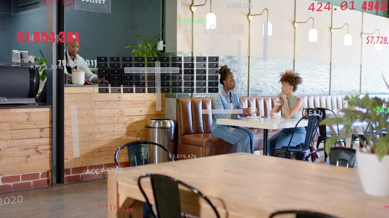 Grafici che appaiono, due donne che discutono un notebook per la revisione dei dati mentre un barista prepara bevande.