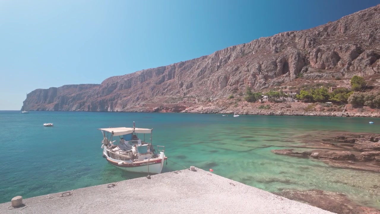 Davetkar masmavi deniziyle manzaralı Yunan Akdeniz Gerolimenas limanı, yavaş pan çekim.