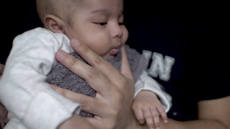 Father-Gently-Rubbing-His-2-Month-Old-Son-On-The-Back-To-Help-Him-Burp-After-Drinking-Milk-On-His-Lap