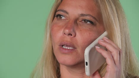 mujer rubia teniendo una frustrante llamada telefónica conversación en el teléfono estresado pantalla verde clave croma