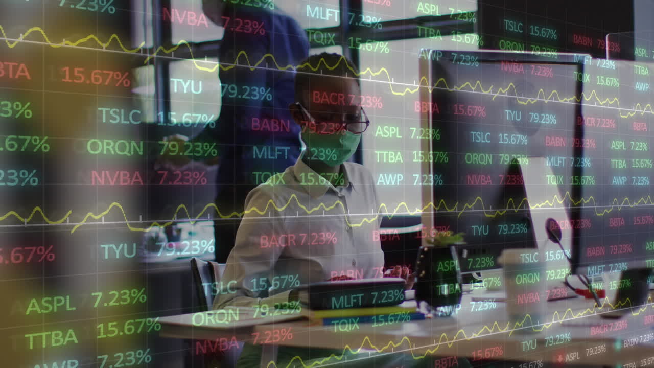 마스크를 쓰고 사무실에서 컴퓨터로 일하는 아프리카계 미국인 여성.