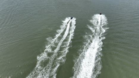 An-aerial-view-over-Gravesend-Bay-in-Brooklyn,-NY-as-two-jet-ski-riders-enjoys-the-beautiful-day