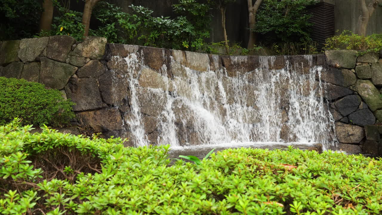 plano medio de una pequeña cascada artificial en el parque ueno, tokio