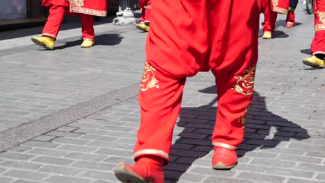 men in red traditional costumes walking and dancing in the street